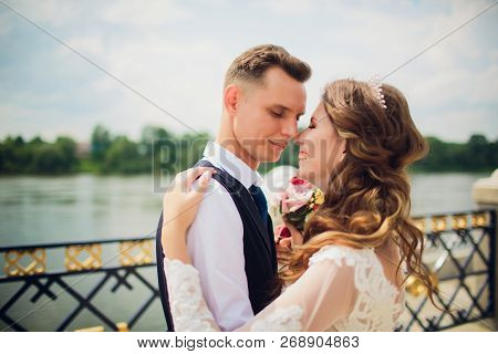 Stylish Bride And Groom Posing On The Background Of The River.