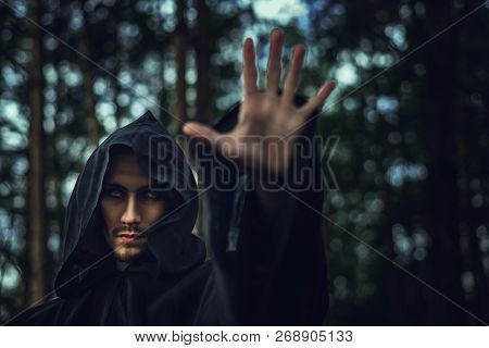 The Black Monk Pointing His Finger In The Woods