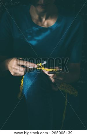 Girl Knits Crochet At Home. Woman Engaged In Needlework. A Knitter Sits On A Sofa And Works. Creativ