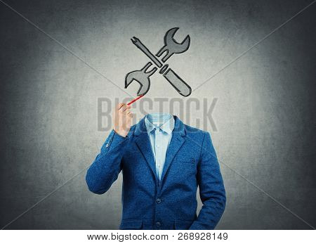 Surreal Image As A Businessman With Invisible Face Holding A Pencil In His Hand Draw Wrench And Scre