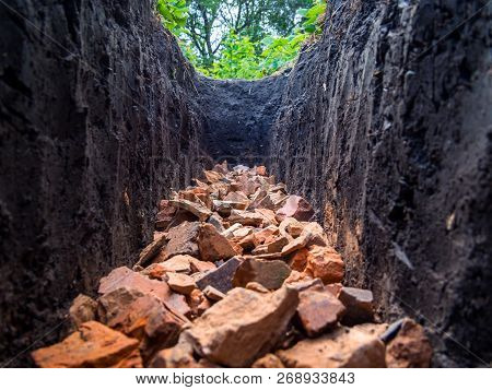 Broken Brick Laid On The Bottom Of A Trench Dug In The Ground