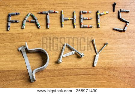 Father`s Day Text Is Laid Out Of A Set Of Screwdrivers And Screws On A Wooden Table. Closeup.