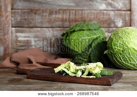 Cutting Board With Chopped Savoy Cabbage On Wooden Table