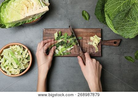 Woman Cutting Savoy Cabbage On Wooden Board At Table, Top View