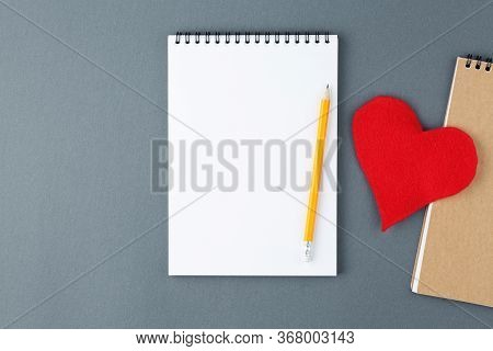 Open Notebook With Clear Page With Yellow Pencil And 
Red Heart On Grey Background. Design Declarati