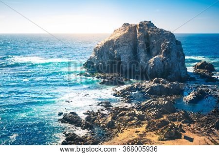 Rocky Island With Birds Near Coastilne Of Pacific Ocean In Chile