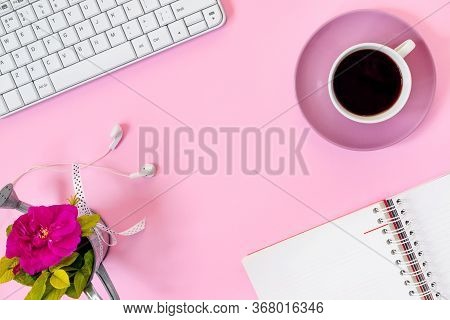 Top View Of Home Office Desk With Laptop, Notebook, Headphones, Computer Mouse And Rose On Pink Pape