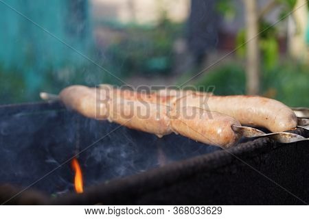 Close Up Of Toasted Sausages On Skewers. Succulent Kupaty Roasting On Chargrill. Concept Of Picnic O