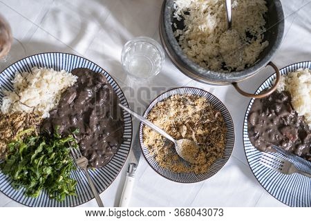Delicious Brazilian Weekend Meal Of Feijoada, Farofa, Rice, Beans, And Collard Greens