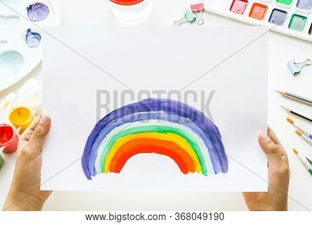 Girl Painting Rainbow On Paper During Covid-19 Quarantine At Home.