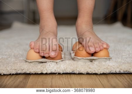 Kid Science Experiments At Home. Close-up Child Walking On Eggs. Strong Concept.