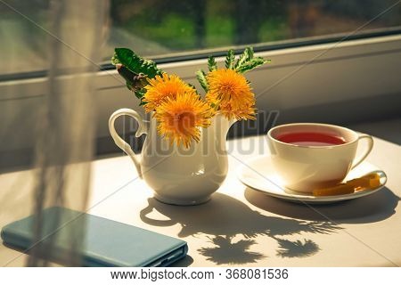 Morning Tea With Light Blue Mobile Phone, Bouquet Of Yellow Spring Dandelion Flowers. Beautifully St