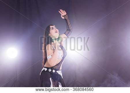Girl Dancing Belly Dance, Fusion Or Tribal. A Woman In A Beautiful Costume Demonstrates Charming And