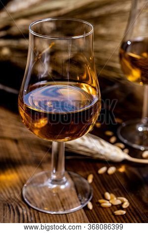 Tasting Glasses With Aged Scotch Whisky Or American Bourbon On Old Dark Wooden Vintage Table With Ba