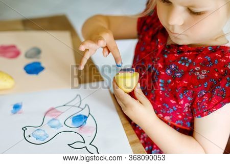 Little Toddler Girl Painting With Finger Colors And Potato Stamp During Pandemic Coronavirus Quarant