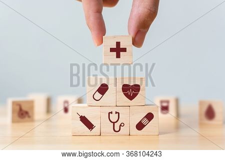 Hand Arranging Wood Block Stacking With Icon Healthcare Medical, Insurance For Your Health Concept