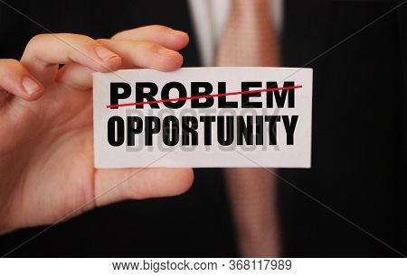 Businessman Holding A Card With Word Problem Strikeout And Opportunity. Problem Turns Into Opportuni