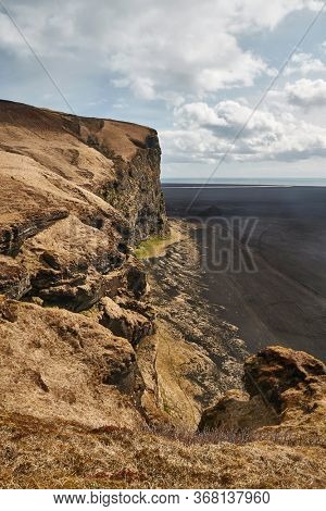 Iceland landscape cliff above black sand plain