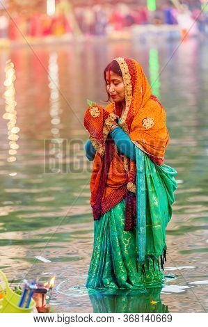 Kathmandu,nepal - November 1,2019: Hindu Devotee Offering Prayers To Sun God Standing In Water Accor