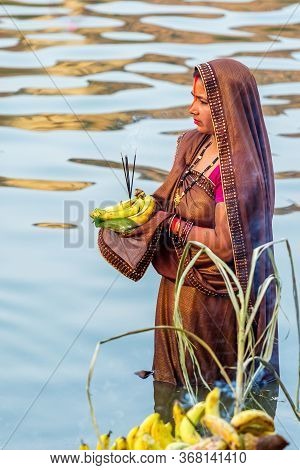 Kathmandu,nepal - November 1,2019: Hindu Devotee Offering Prayers To Sun God Standing In Water Accor
