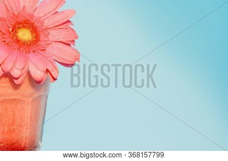 A Glass Of Strawberry Smoothie Stands At The Edge Of The Frame. On Top Is A Aster. The Background Is