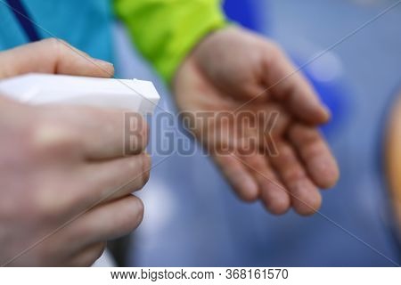 Close-up Of Person Irrigating Disinfecting Liquid On Hand. Prevention Handover Of Dangerous Virus. W