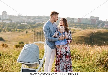 Mom, Dad And Little Girl Having Fun Outdoors In The Grass On Summer Day. Mothers, Fathers And Babys 