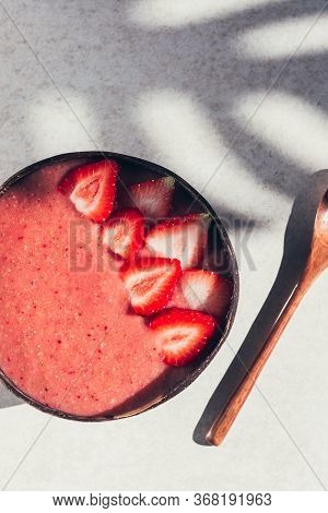 Pink Smoothie From Banana And Strawberries With Pieces Of Strawberries In The Coconut Shell Bowl, St