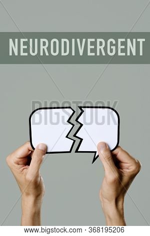 closeup of a young caucasian man holding a broken speech balloon in his hands and the text neurodivergent on a gray background