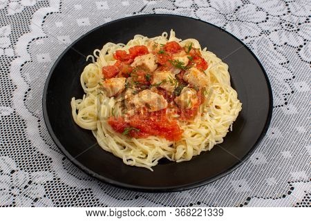 A Top View Pasta Cooked Tasty With Chicken Wings Cooked And Tomatoe Sauce Inside Black Palte On The 