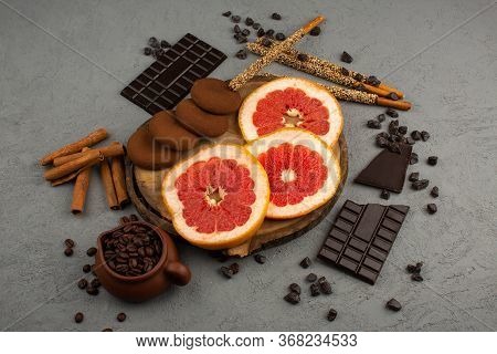 A Top View Grapefruit Sliced Along With Choco Cookies Brown Coffee Seeds Choco Bars On The Grey Back