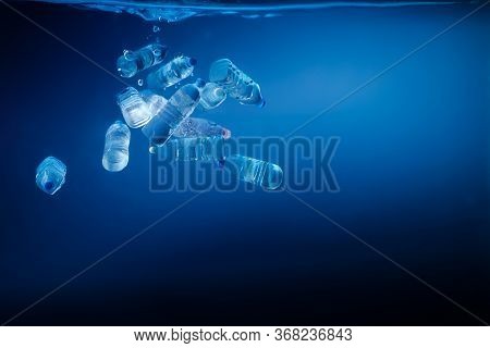 Plastic Bottles Sinking In To The Ocean. Enviromental Polution Concept. World Ocaens Day