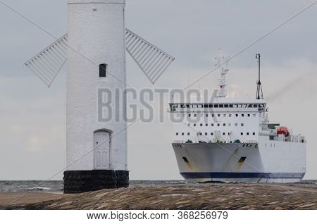 Navigation Sign Stawa Mills And Passenger Ferry  - A Ship On The Horizon Sailing To The Seaport