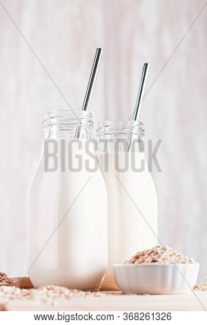 Non Dairy Oat Milk In Glass Bottles With Reusable Metal Straws. Healthy Vegan Milk Alternative Still