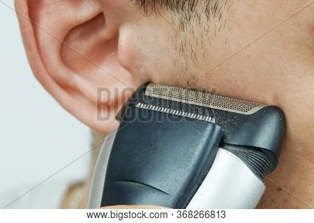 Man Shaves Off His Sideburns With An Electric Razor Close Up