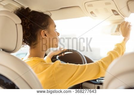 Buying New Car. African Woman Adjusting Mirrors Checking Auto During Test Drive Sitting In Drivers S