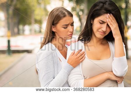 Compassionate Friend Supporting Crying Girl Standing Outdoors In Park. Female Friendship. Empty Spac