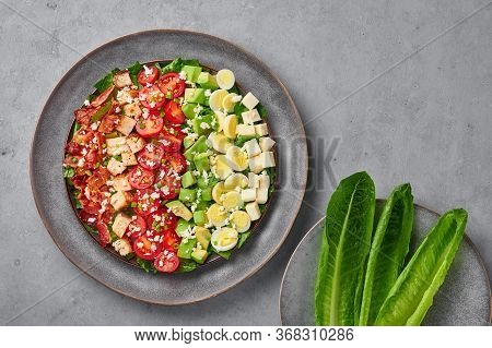 Cobb Salad On Gray Plate On Concrete Backdrop. American Cuisine Dish With Tomatoes, Chicken, Bacon,