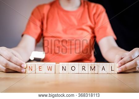 Woman\'s Hand Putting Wooden Cubes With Concept New Or Next Normal. New Normal Life After Covid Cris