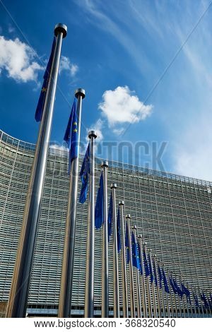 Helplessly drooping EU European Union flags with the European Comission building in Background. Brussles, Belgium