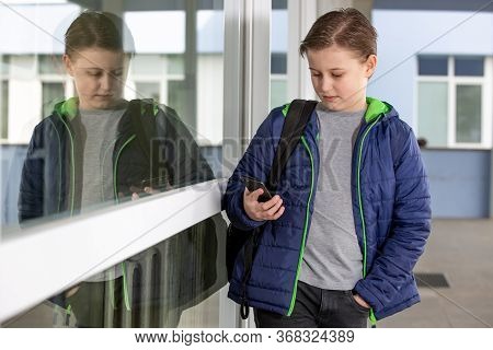 Truancy Concept, Young Boy Staying Away From The School And Playing Games On The Mobile, Absence Fro