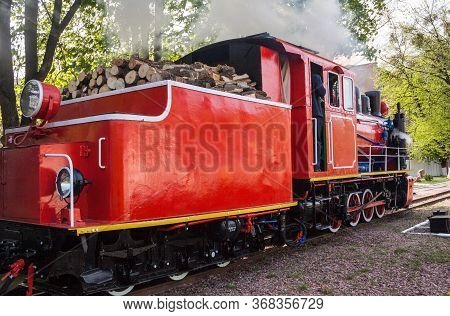 Old Steam Locomotive Blowing Off The Steam Out Of The Whistle. Tender Filled With Wood.