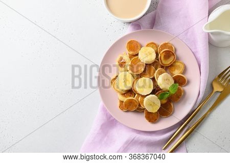 Homemade Tiny Cerel Pancakes With Banana On White Table. View From Above. Copy Space.