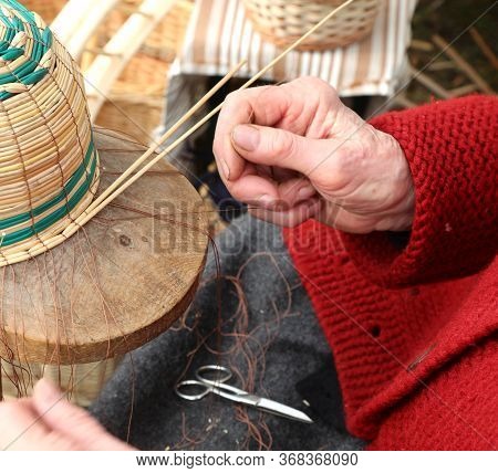 Hands With Arthrosis Of The Elderly Lady While She Creates A Wicker Basket For Sale At The Market