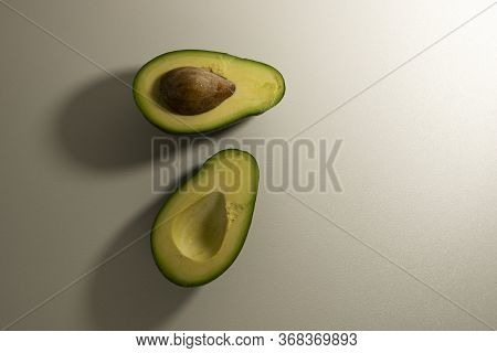 Two Halves Of Avocado Fruit With Kernel On A Light Background. Top View