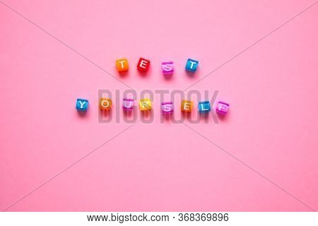 Colorful Letters Of Beads Concept. Quote Test Yourself On The Pink Background.  Testing Concept.