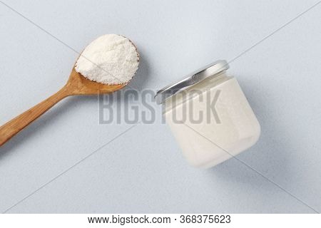 Vegan Organic Paste Of Coconut In Glass Jar And Coconut Flour In Spoon On Light Blue Background, Urb