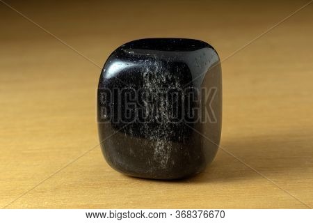 Black Onyx Polished Gemstone From China Over A Wooden Table