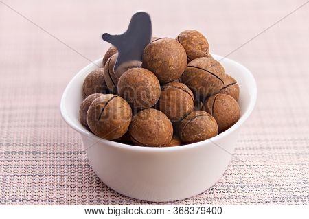 Delicious Macadamia Nuts On A Plate On A Wooden Background