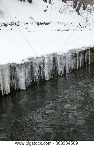 Urban Stream In Winter. Icicles On Concrete River Banks. The Lybid River (kyiv, Ukraine) In The Snow